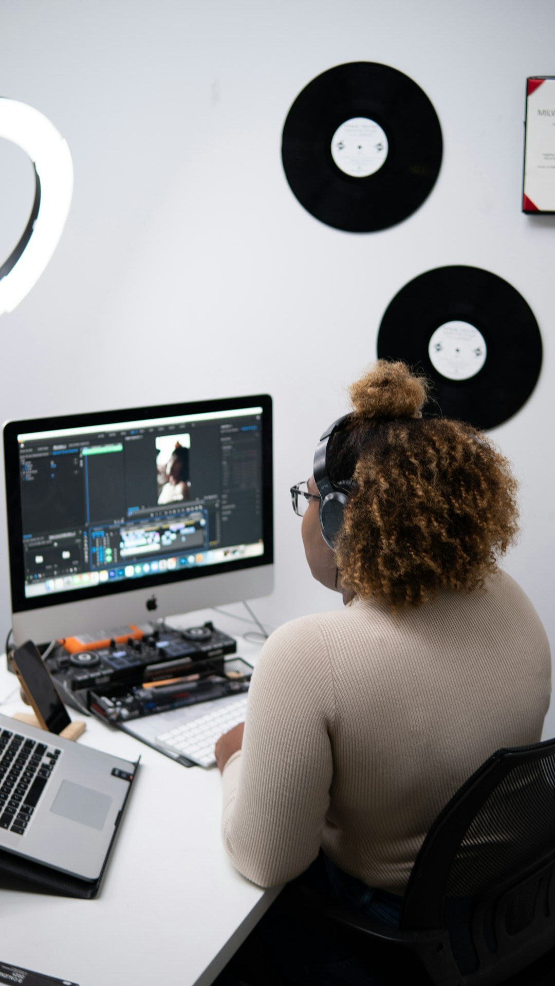 Video editor working at a multi-screen editing suite with archive footage